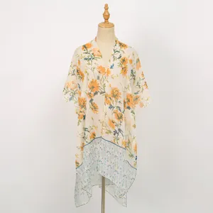 Détail d'un châle en voile à imprimé floral avec chrysanthème jaune et ourlet bleu