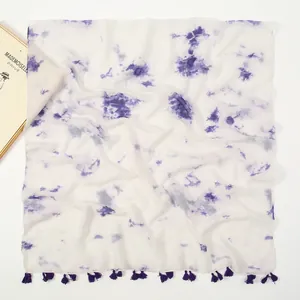 Detail of tie-dye cotton linen scarf featuring purple patterns and fringe tassels