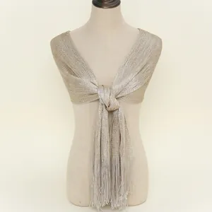 Detail of light gold metallic shawl with fine knit texture and elegant long fringe tassels