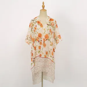 Vue détaillée d'un châle léger en voile avec des motifs de fleurs orange vif