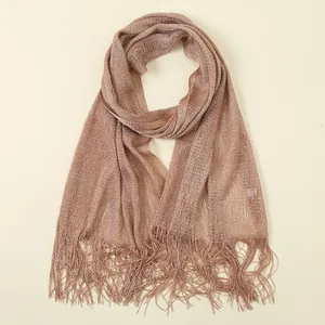Close-up detail of metallic rose gold shimmer fabric with long tassel fringe edges