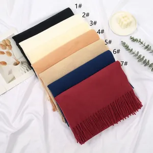 Close-up of fringe details and textured knit fabric in various warm autumn colors