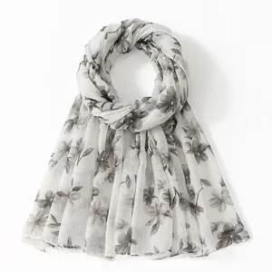 Detail of floral printed voile scarf with translucent fabric and gray flower patterns