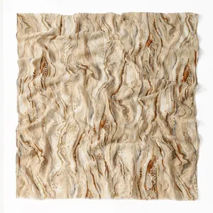 Detail of artistic wave pattern on a beige ethnic linen scarf with frayed edges