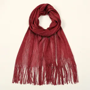 Detail of burgundy mesh shawl with metallic glitter finish and long decorative fringes