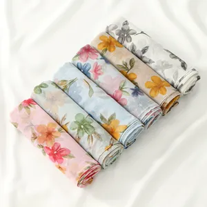 Close-up of floral print voile scarves in assorted colors on soft white fabric