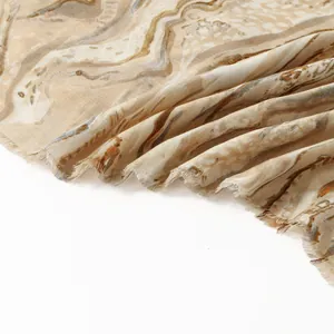 Detailed view of the marble print cotton linen scarf with soft frayed tassel edges