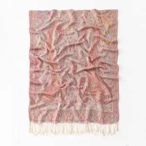 Gros plan sur le motif paisley et les longues franges blanches de ce châle chic