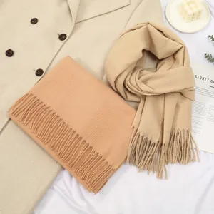 Soft faux cashmere fringe scarves in camel and beige displayed on a coat