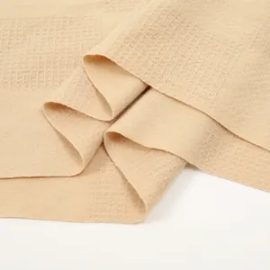 Detailed macro view of the cream waffle weave texture and thick cashmere-like fabric
