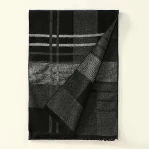 Détail d'une écharpe à carreaux noirs et gris en cachemire avec des finitions à franges