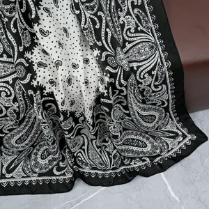 Close-up of paisley and polka dot silk texture on a black and white fashion scarf