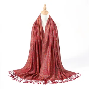 Close-up of red paisley woven shawl showing intricate patterns and fringe detailing