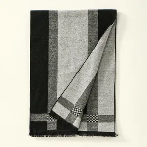 Detail shot of the thick cashmere-feel scarf texture and soft fringes on the edges