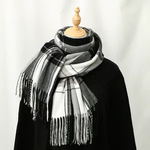 Classic black and white plaid cashmere-like scarf with fringe on a wooden mannequin