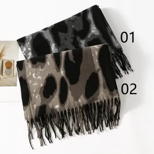 Detail of leopard print tassel scarves in grey and brown soft cashmere-like fabric