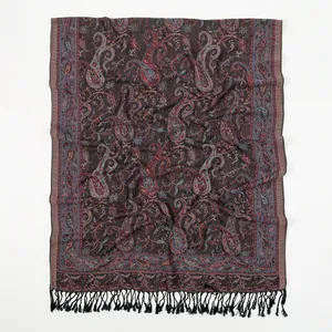 Detail of vintage paisley pattern on a thick bohemian shawl with fringe trim