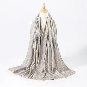 Detail view of paisley jacquard pattern and white tassel fringe on women's long shawl