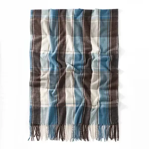 Detail of plaid cashmere-feel scarf featuring soft fringe edges and thick woven texture