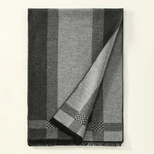 Detailed close-up of the thick striped cashmere-like fabric and black tassel fringe
