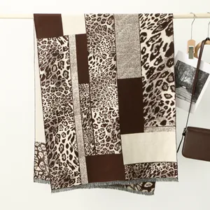 Detail of cashmere-like scarf showing leopard print and geometric patchwork texture