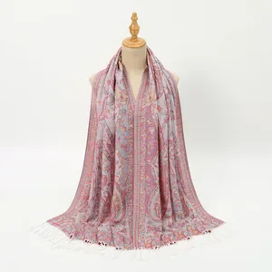 Detail of red paisley jacquard scarf showing intricate ethnic patterns and white tassels
