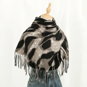 Detail of soft leopard print cashmere scarf with fringe tassels on mannequin