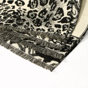 Detailed close-up of leopard print scarf showing thick knit texture and soft fringe edges