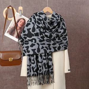 Détails de l'écharpe épaisse à motif léopard avec franges sur un manteau en laine