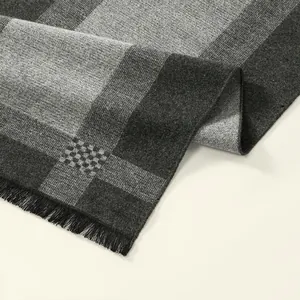 Detailed view of striped cashmere-feel scarf with black tassels and soft woven texture
