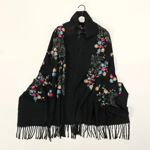 Detail of colorful floral embroidery on a soft black cashmere-feel pashmina shawl