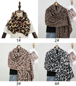 Collage of four distinct leopard print cashmere-like scarves with tassel fringe details