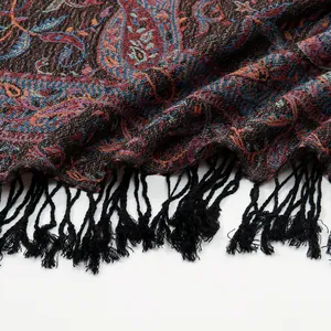Close-up of paisley jacquard fabric showing intricate weaving and black fringe tassels