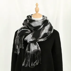 Fashionable black and grey leopard cashmere-like scarf with tassels on mannequin