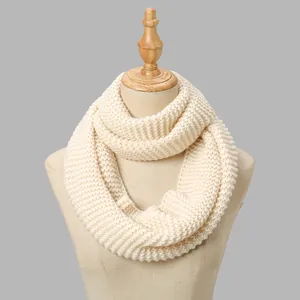 Close-up of thick ribbed knit texture on a beige infinity scarf shown on a mannequin
