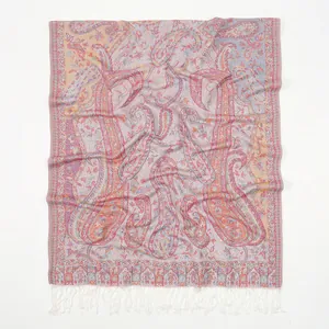 Detail shot of multicolor paisley pattern and soft white tassels on a lightweight scarf