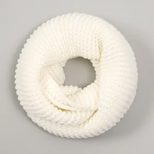 Macro detail of chunky white knit snood showing thick polyester yarn and warm texture