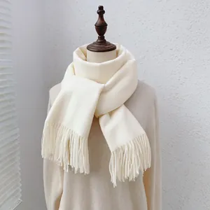 Detailansicht eines cremefarbenen Kaschmir-Schals mit feiner Stricktextur und Fransen