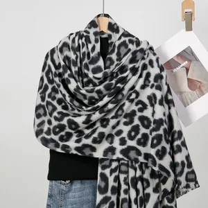 Detailed view of leopard print scarf texture with delicate fringe and thick cashmere feel