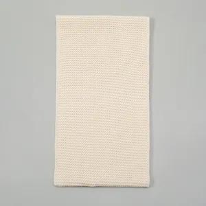 Close-up of ivory knitted scarf texture showing detailed honeycomb knitting pattern