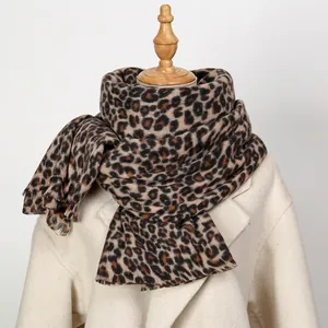 Macro shot of thick leopard print cashmere-like shawl scarf on mannequin over white coat