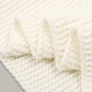 Detailed macro shot of thick white knit texture on winter thermal scarf fabric