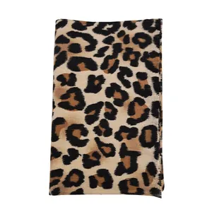Detail of leopard print scarf featuring fringed edges and soft cashmere-like texture