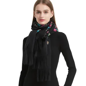 Detailed embroidery of colorful flowers on a black cashmere-feel scarf with long tassels