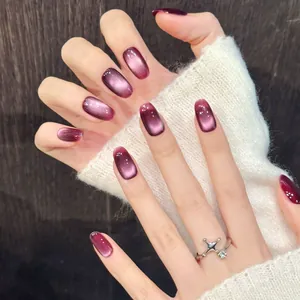 Short square press-on nails with purple cat-eye effect and silver crown cross ring
