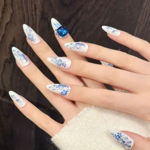 Faux ongles stiletto style porcelaine bleue et blanche avec ornement de gemme bleue
