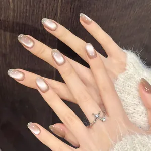 Nude champagne cat-eye press-on nails with glitter accents and silver star ring