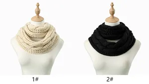 Detail view of cable knit infinity scarves in cream and black on display stands