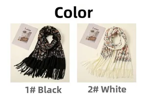 Detail of ginkgo embroidery and tassel fringe on black and cream cashmere scarves