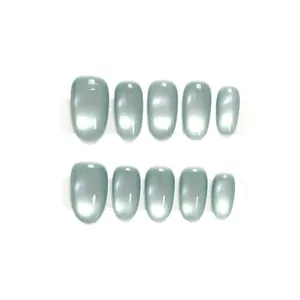 Faux ongles œil de chat vert menthe étincelants de forme ovale sur carte blanche
